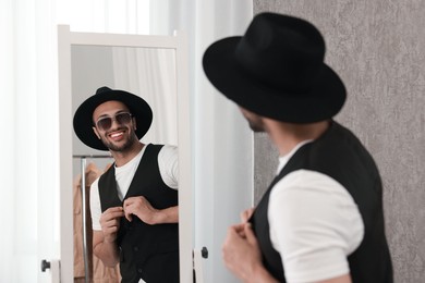 Photo of Smiling man looking at mirror at home