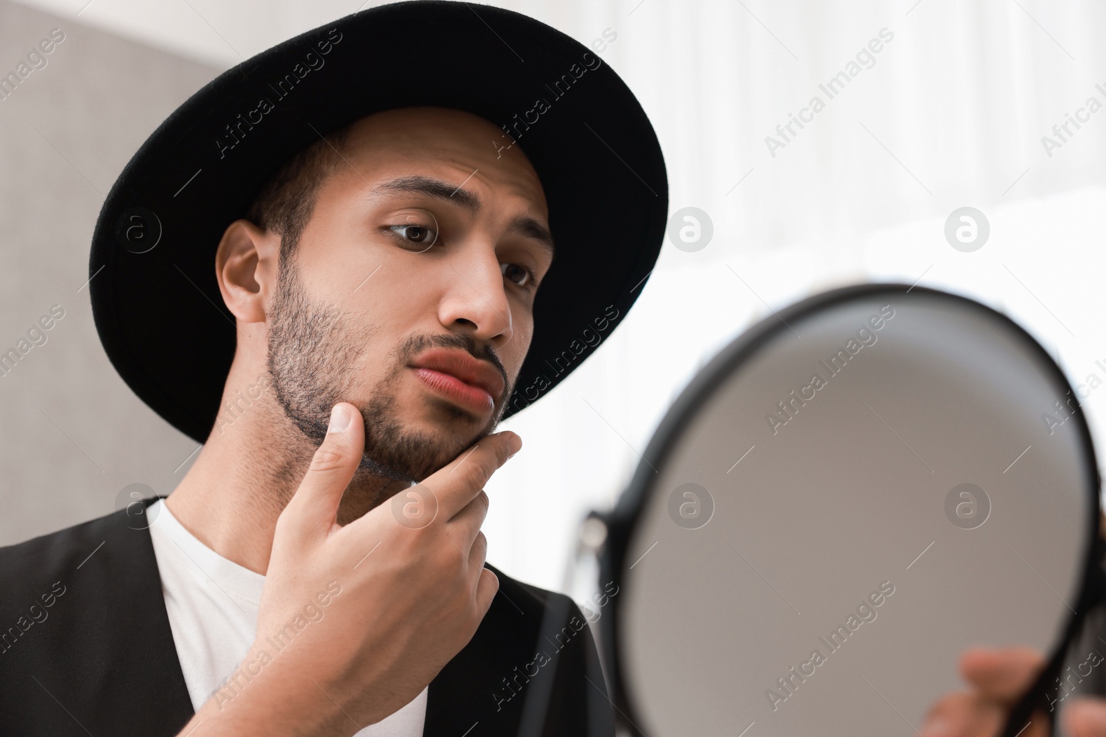 Photo of Handsome man looking at mirror at home