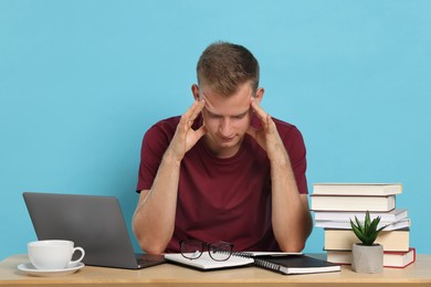 Photo of Student preparing for exam at table against light blue background