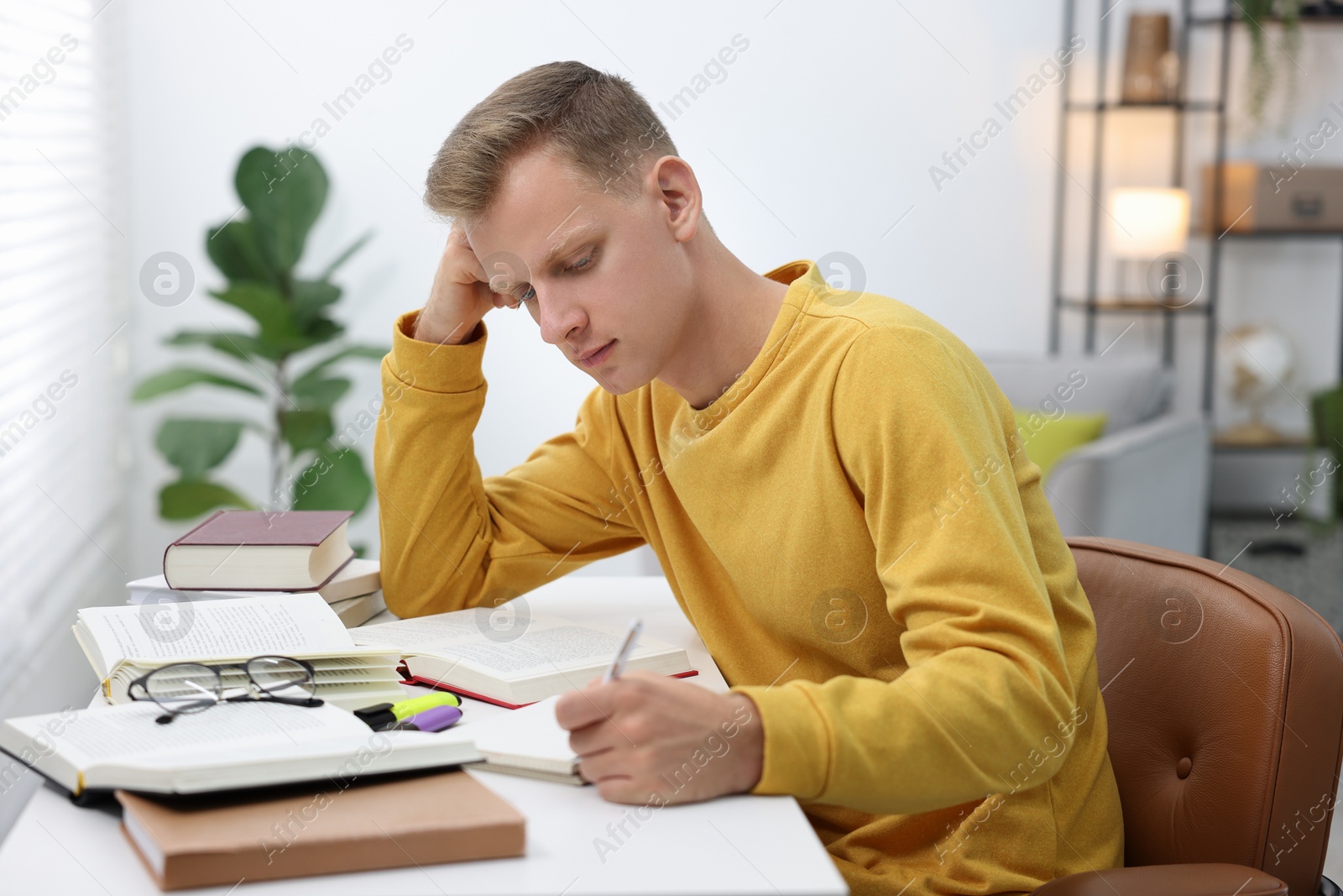 Photo of Student preparing for exam at table indoors