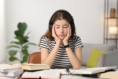 Photo of Preparing for exam. Tired student sleeping at table indoors