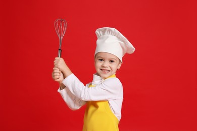 Photo of Little girl with whisk pretending to be chef on red background. Dreaming of future profession