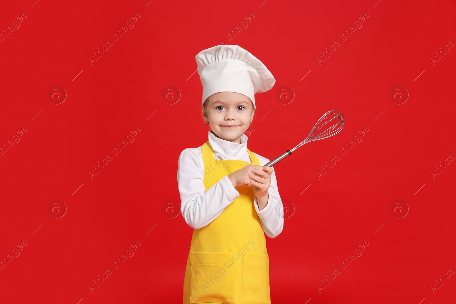 Photo of Little girl with whisk pretending to be chef on red background. Dreaming of future profession