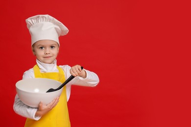 Photo of Little girl with bowl and spoon pretending to be chef on red background, space for text. Dreaming of future profession