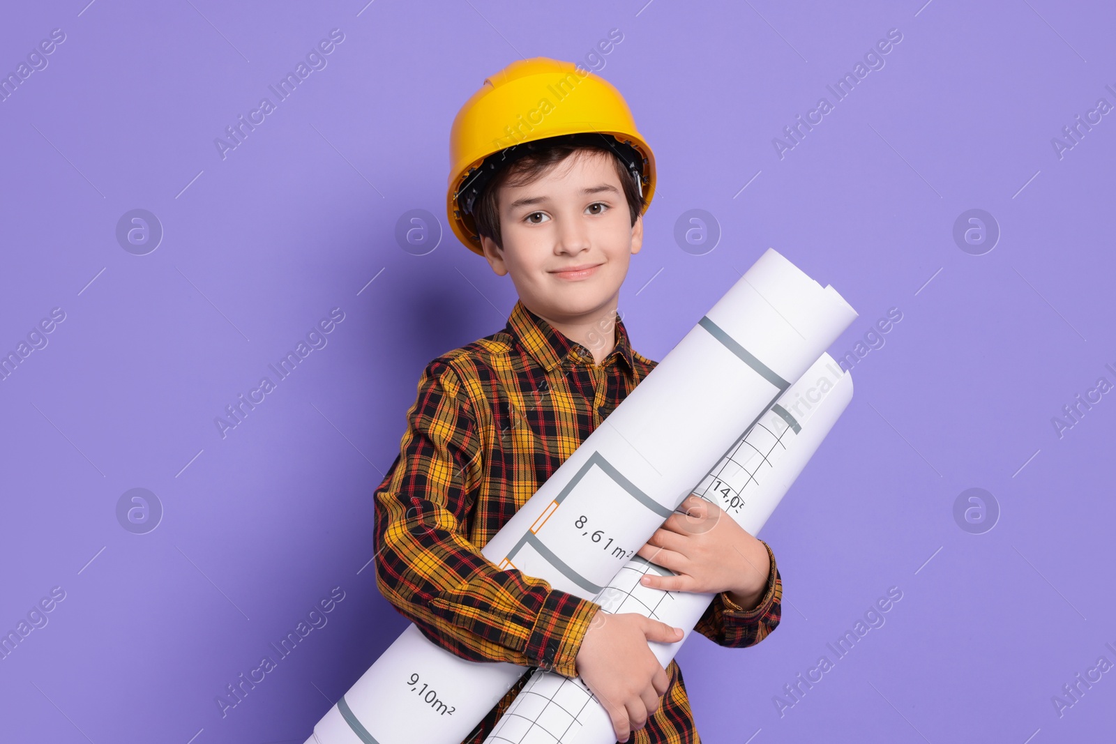 Photo of Boy with house plan pretending to be architect on violet background. Dreaming of future profession