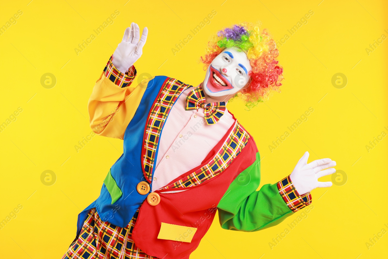 Photo of Portrait of happy clown on yellow background