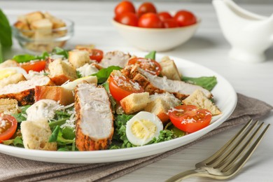 Photo of Tasty Caesar salad with chicken and tomatoes on white wooden table, closeup