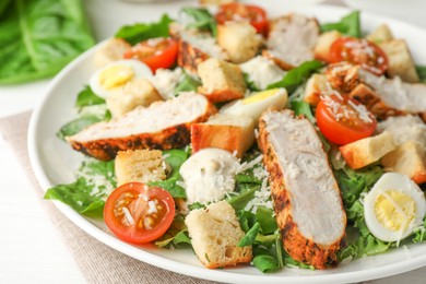 Photo of Tasty Caesar salad with chicken and tomatoes on white wooden table, closeup