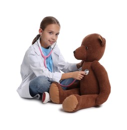 Girl with stethoscope and toy pretending to be doctor on white background. Dreaming of future profession