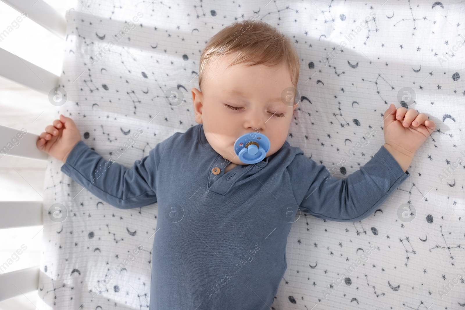 Photo of Cute baby sleeping in crib at home, top view