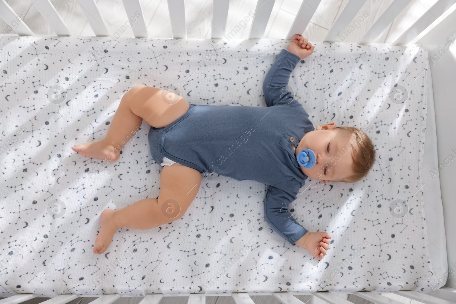 Photo of Cute baby sleeping in crib at home, top view