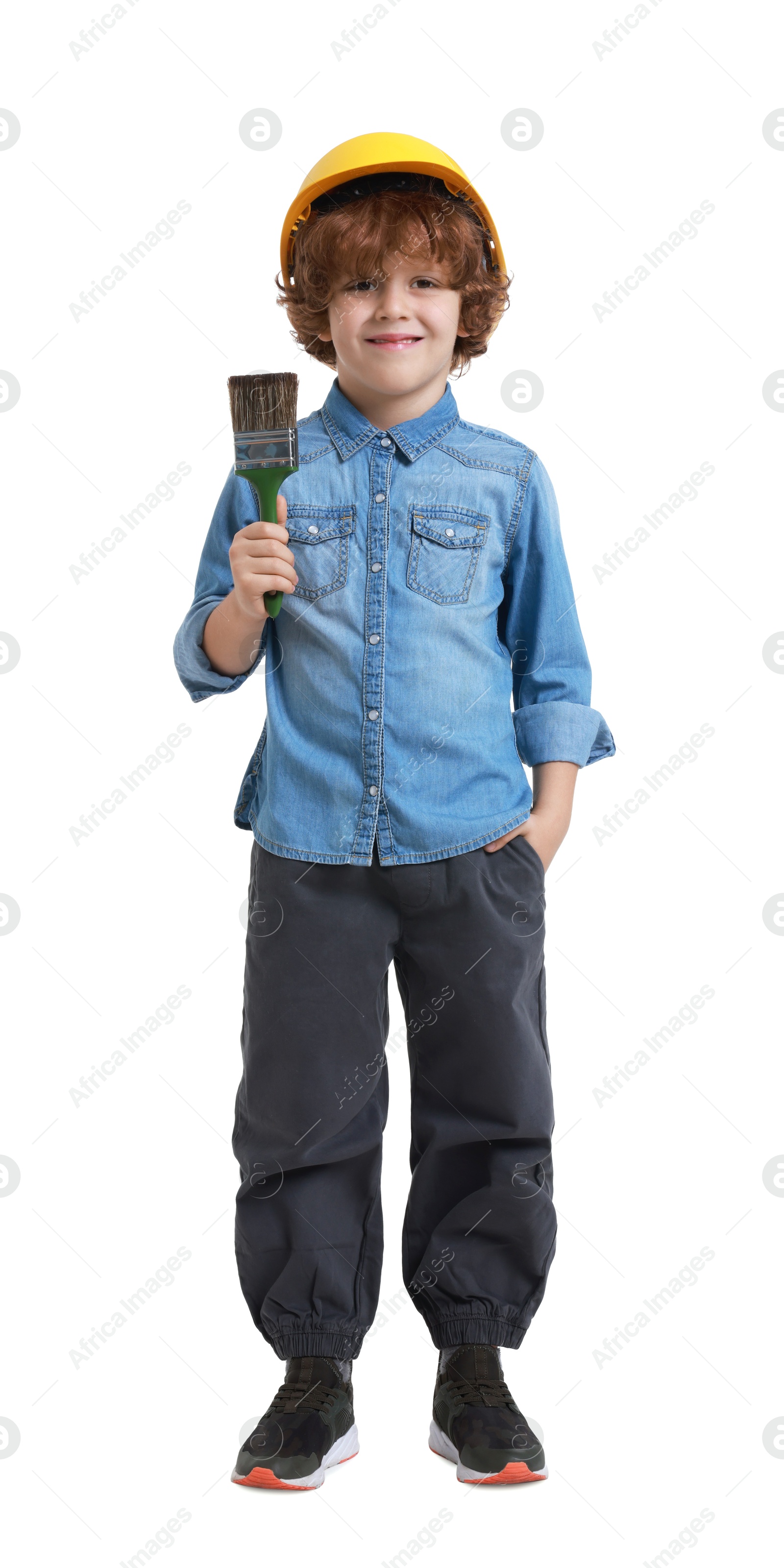 Photo of Little boy in hard hat with paint brush on white background. Dreaming about future profession