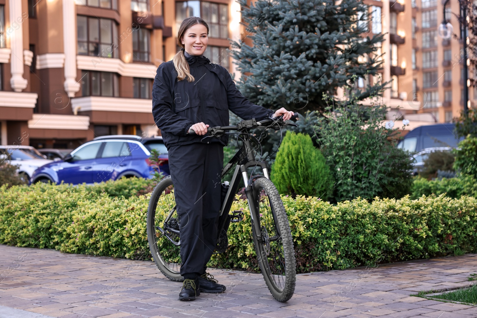 Photo of Smiling woman with bicycle outdoors. Healthy lifestyle