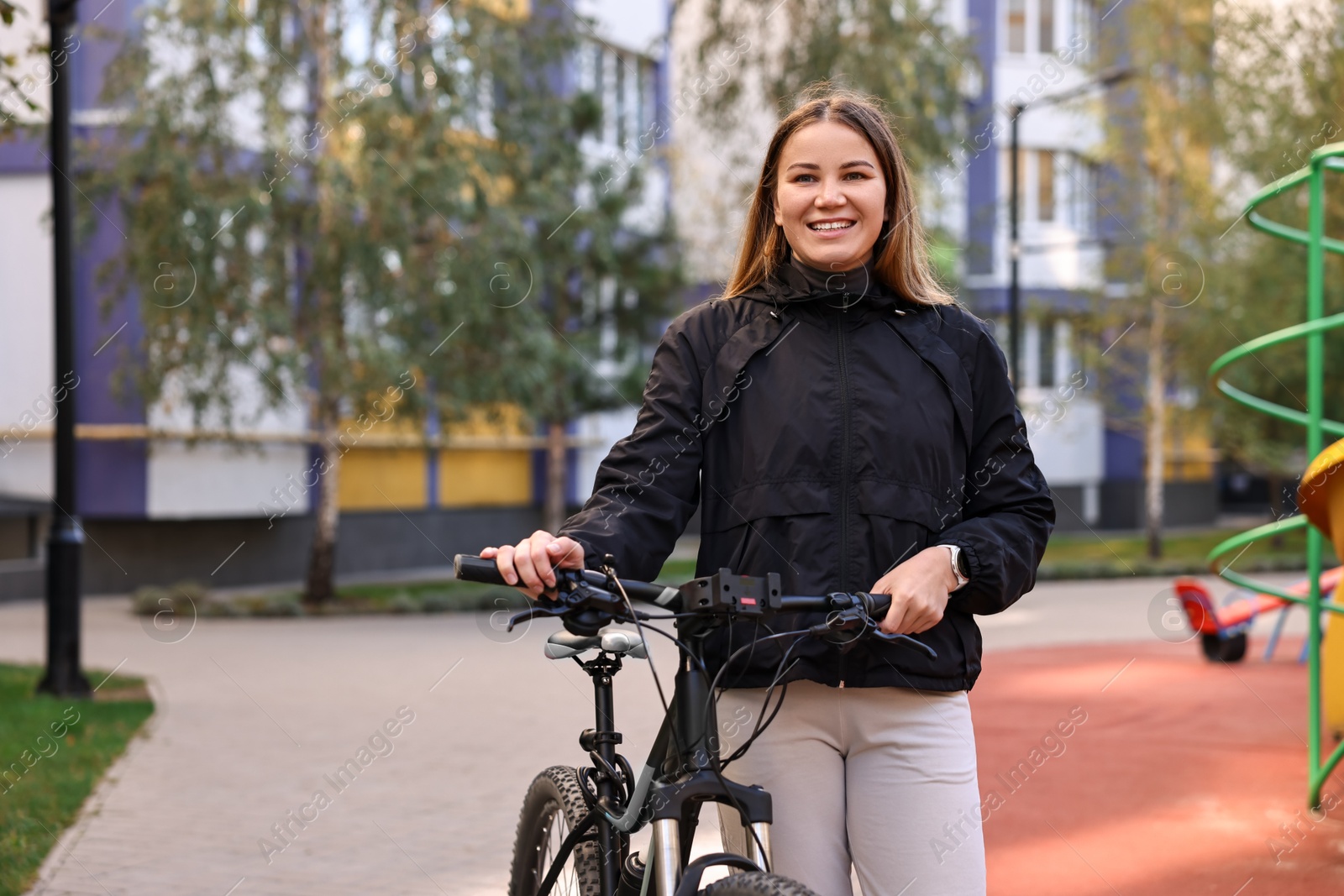 Photo of Smiling woman with bicycle outdoors. Healthy lifestyle