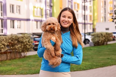 Woman with cute Toy Poodle dog outdoors