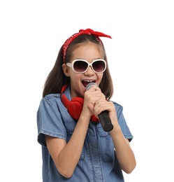 Photo of Girl with sunglasses, headphones and microphone pretending to be singer on white background. Dreaming of future profession