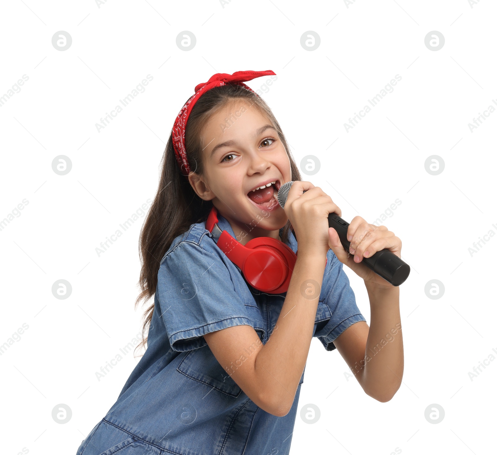 Photo of Girl with headphones and microphone pretending to be singer on white background. Dreaming of future profession