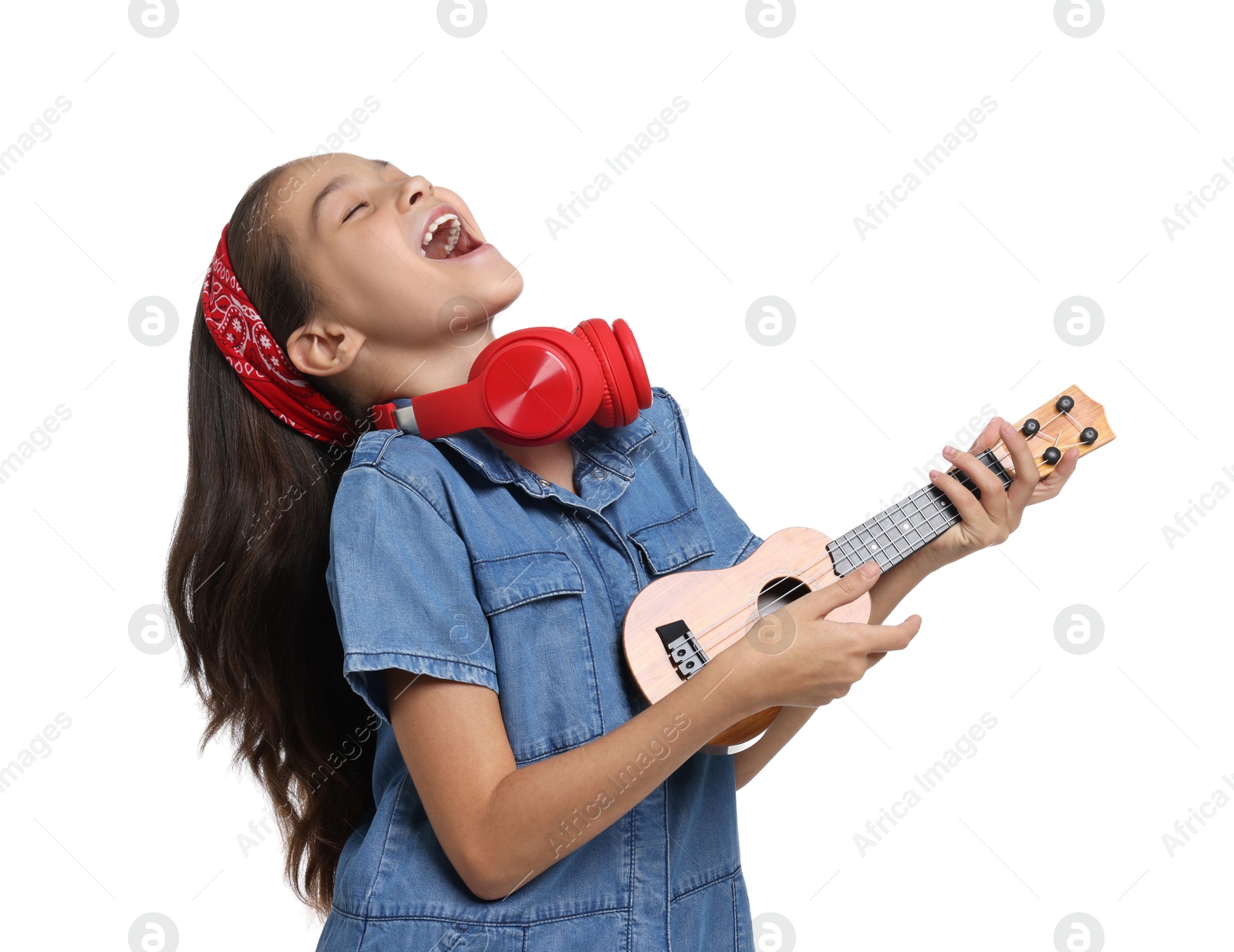 Photo of Girl with headphones and ukulele pretending to be musician on white background. Dreaming of future profession