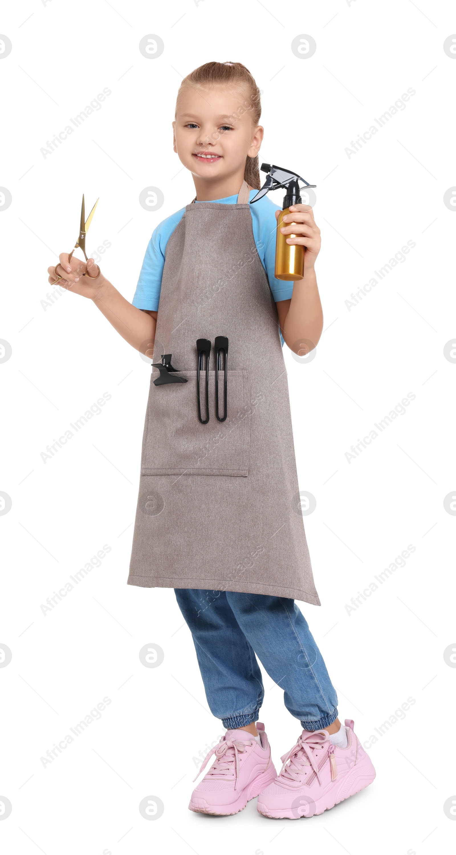 Photo of Little girl with scissors and sprayer pretending to be hairdresser on white background. Dreaming of future profession