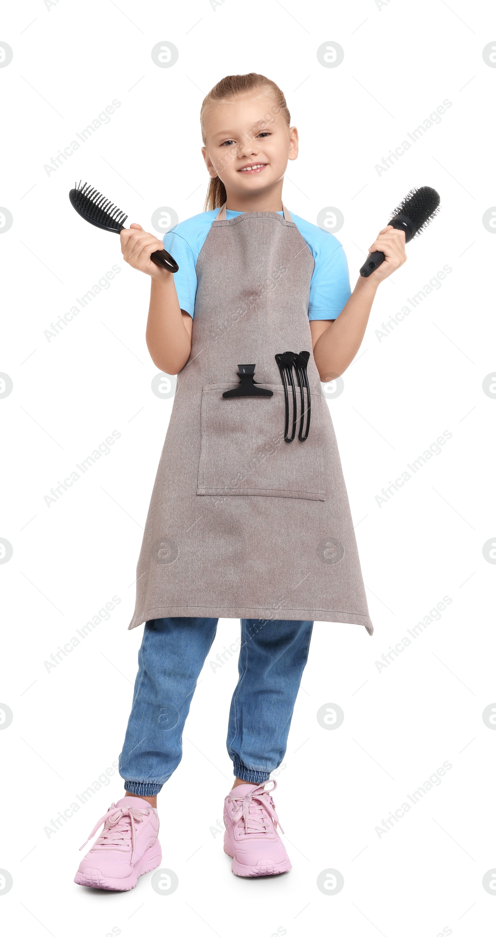 Photo of Little girl with brushes pretending to be hairdresser on white background. Dreaming of future profession