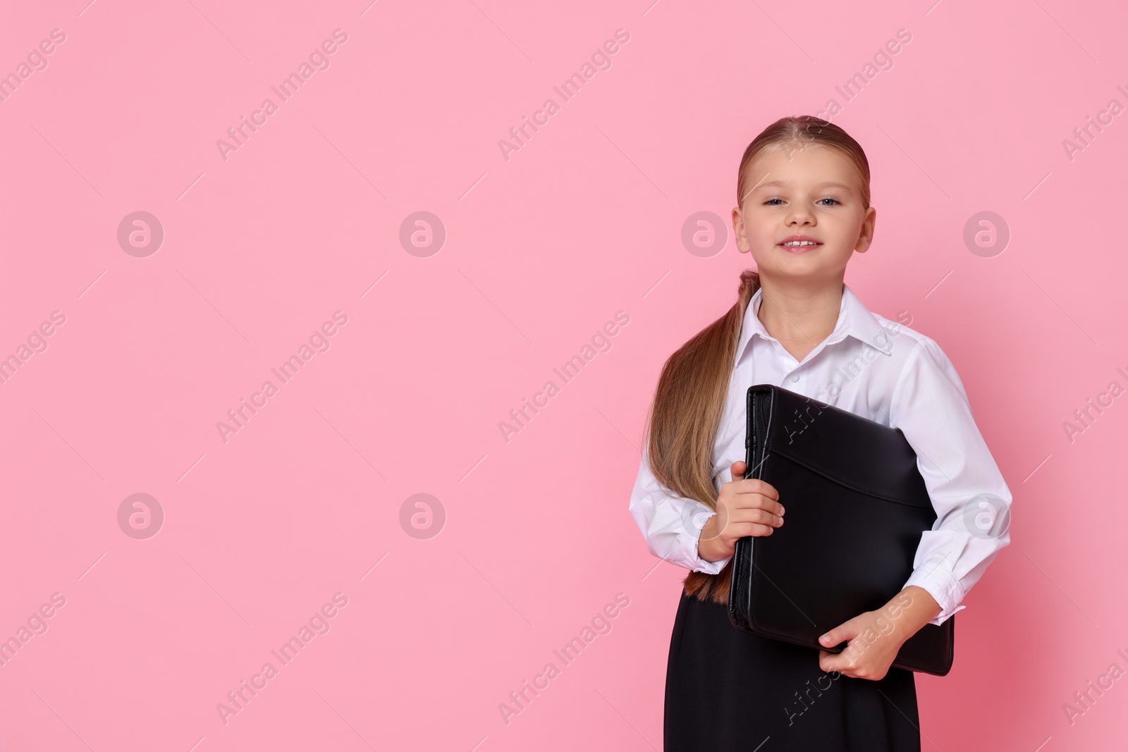 Photo of Little girl with briefcase pretending to be businesswoman on pink background, space for text. Dreaming of future profession