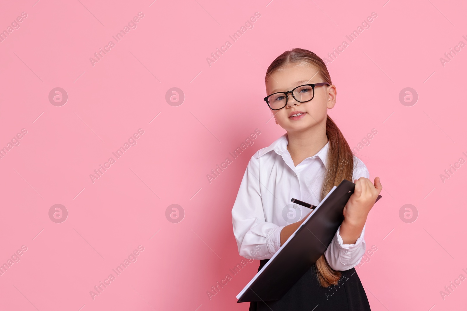 Photo of Little girl with clipboard pretending to be accountant on pink background, space for text. Dreaming of future profession