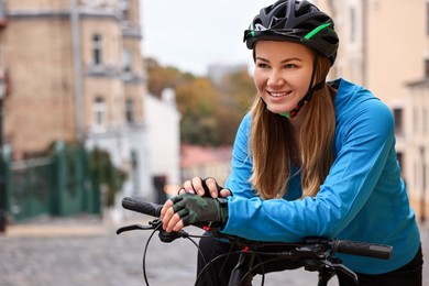 Photo of Woman with helmet and bicycle outdoors, space for text