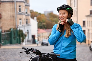 Photo of Woman with helmet and bicycle outdoors, space for text