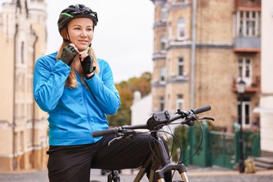 Photo of Woman with helmet and bicycle outdoors, space for text