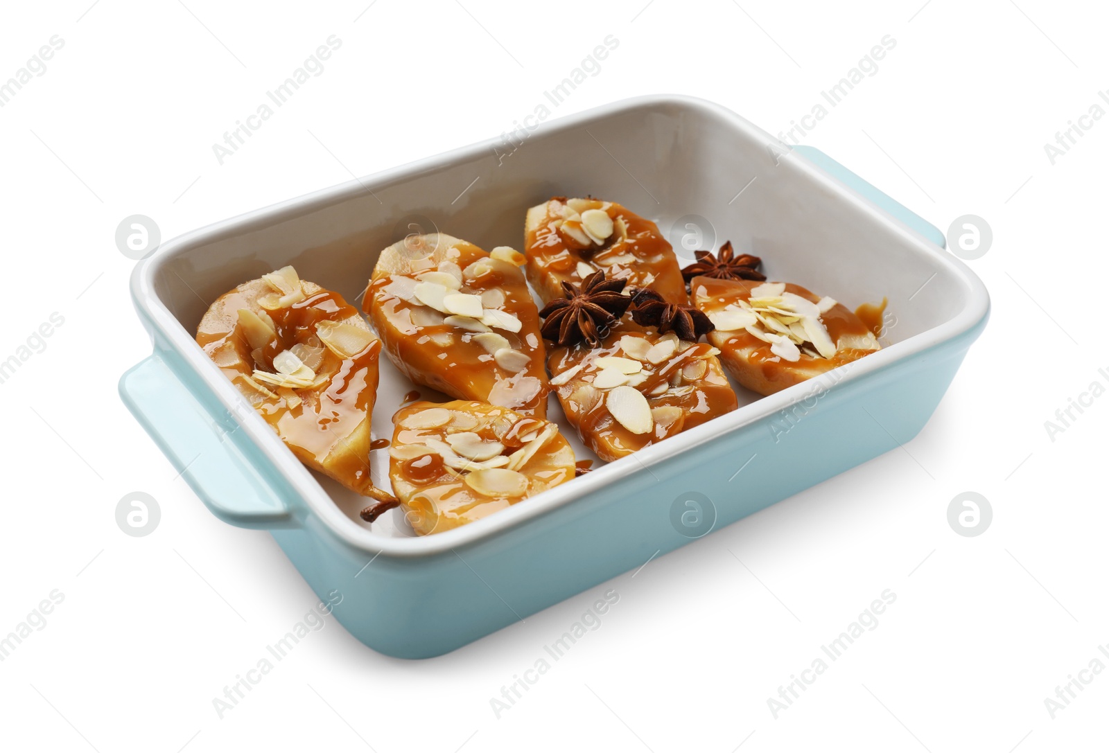 Photo of Delicious pears with caramel sauce, almond flakes and anise stars in baking dish isolated on white