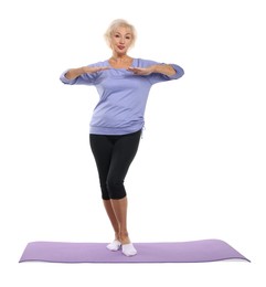 Photo of Senior woman exercising with fitness mat on white background