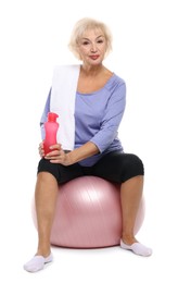 Photo of Senior woman with fitness ball, towel and water on white background