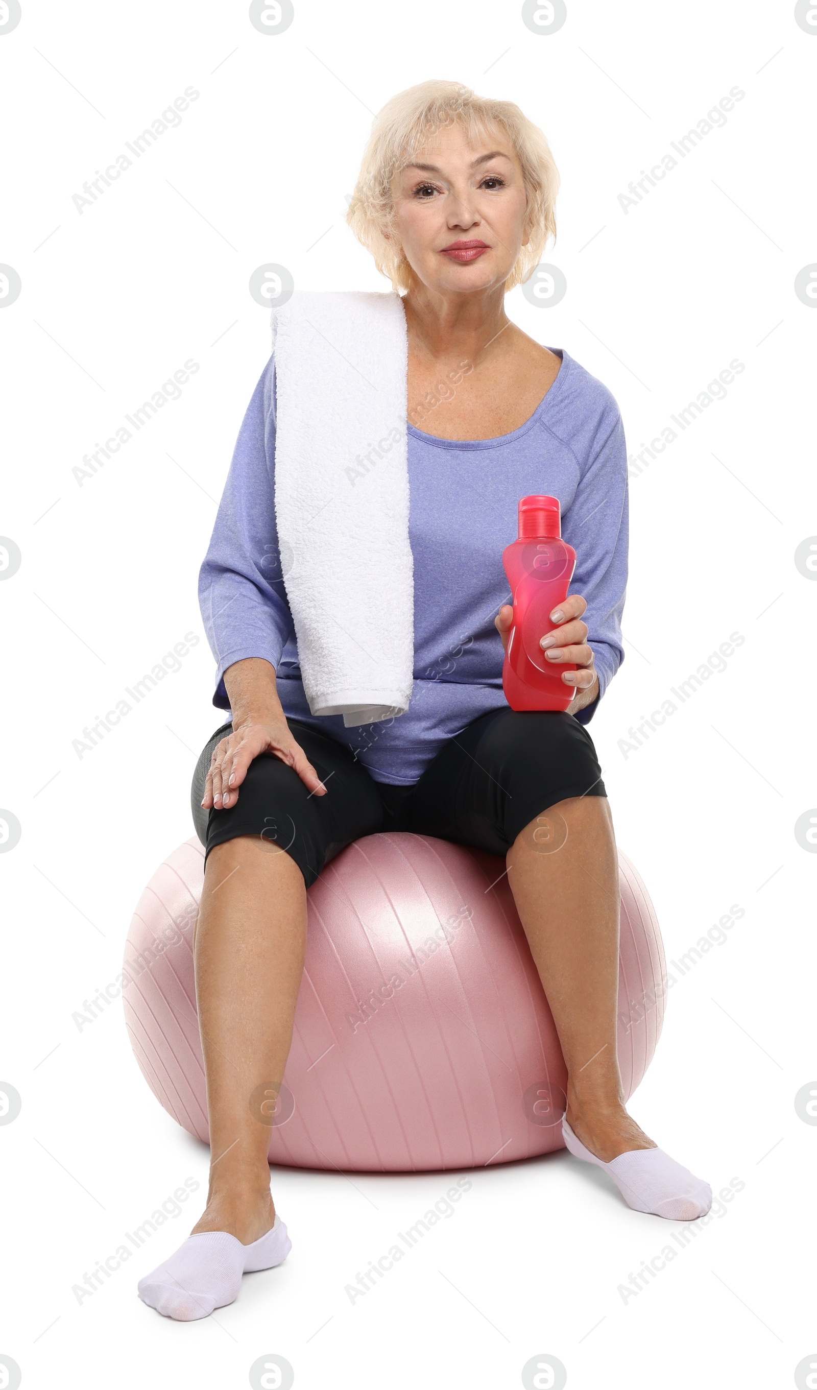 Photo of Senior woman with fitness ball, towel and water on white background