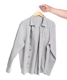 Photo of Woman holding hanger with light grey shirt on white background, closeup