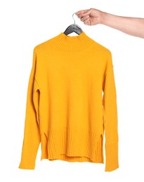 Photo of Woman holding hanger with orange sweater on white background, closeup