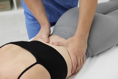 Photo of Osteopath massaging woman's back in clinic, closeup. Manual therapy