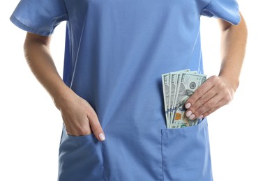 Photo of Corruption concept. Doctor putting dollar banknotes into her pocket on white background, closeup