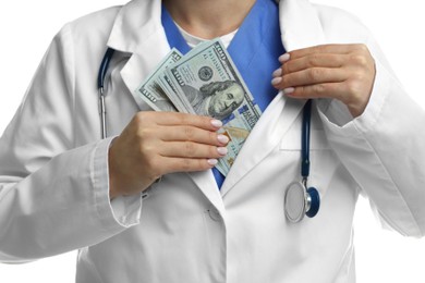 Photo of Corruption concept. Doctor putting dollar banknotes into her coat on white background, closeup