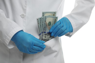 Photo of Corruption concept. Doctor putting dollar banknotes into her pocket on white background, closeup