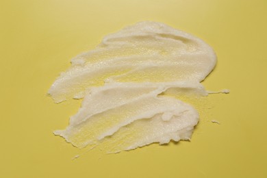 Photo of Sample of body scrub on yellow background, top view