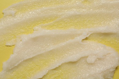 Sample of body scrub on yellow background, closeup