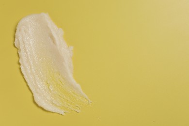 Photo of Sample of body scrub on yellow background, top view. Space for text