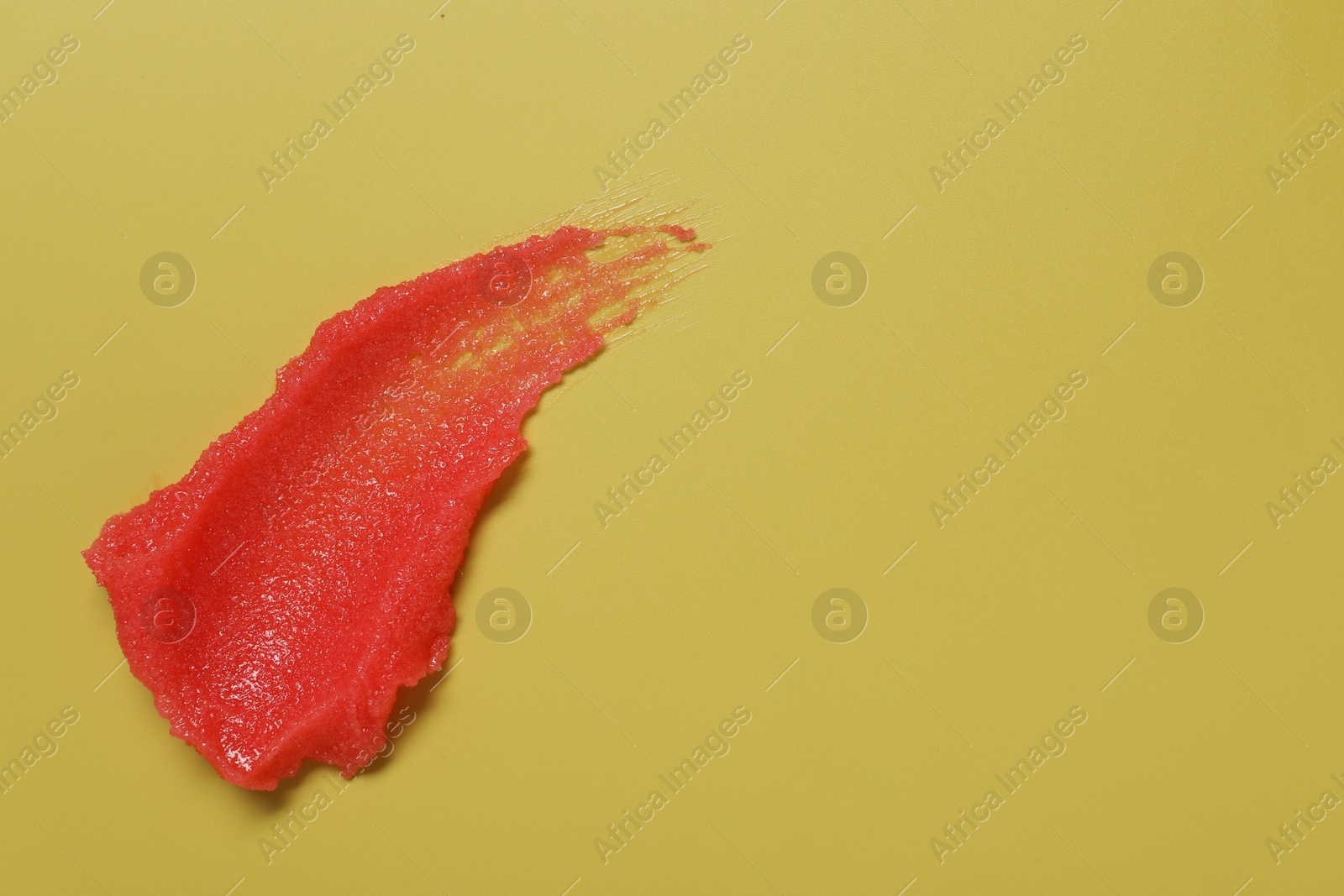 Photo of Sample of body scrub on yellow background, top view. Space for text