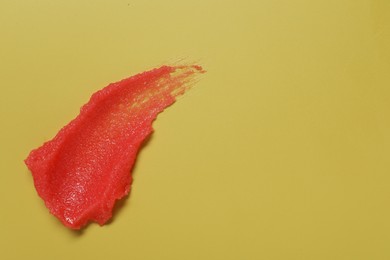 Photo of Sample of body scrub on yellow background, top view. Space for text