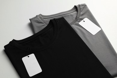 Photo of Different blank t-shirts on white background, closeup. Mockup for design