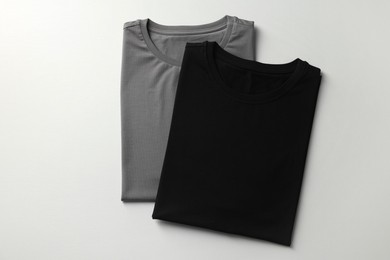 Photo of Different blank t-shirts on white background, top view. Mockup for design