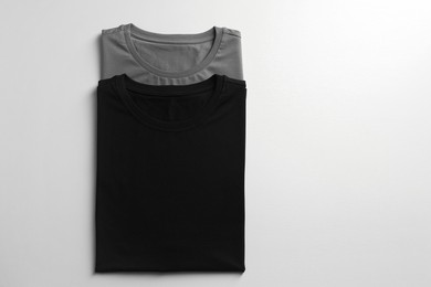 Photo of Different blank t-shirts on white background, top view. Mockup for design