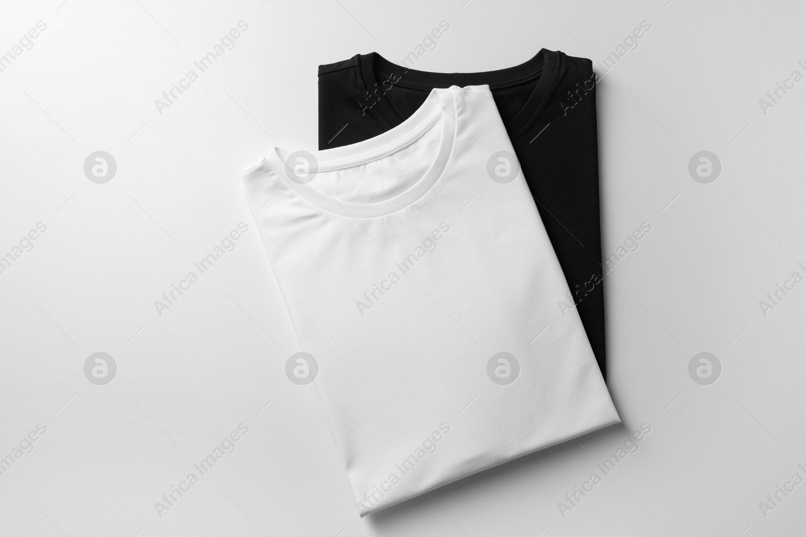 Photo of Different blank t-shirts on white background, top view. Mockup for design