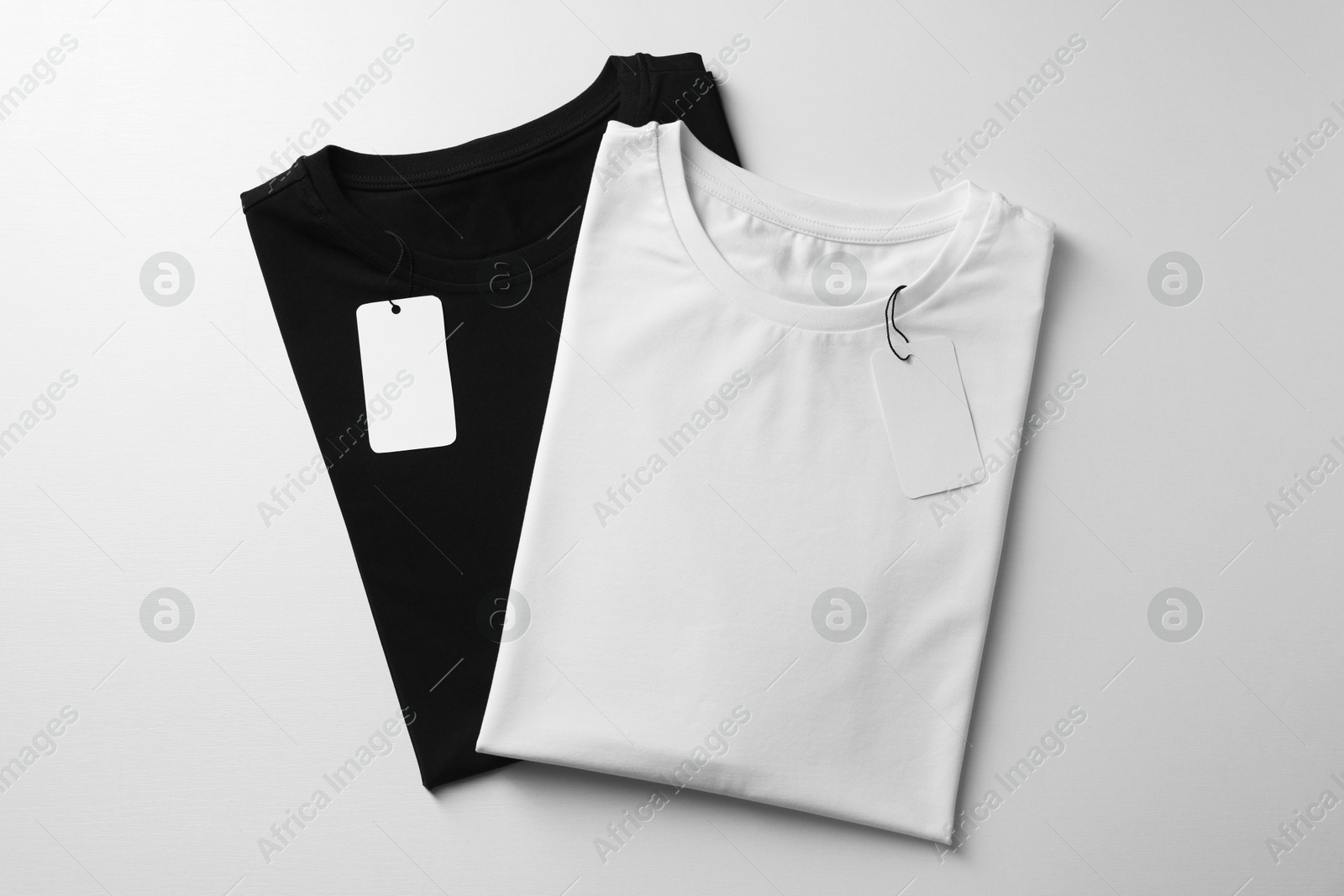 Photo of Different blank t-shirts on white background, top view. Mockup for design