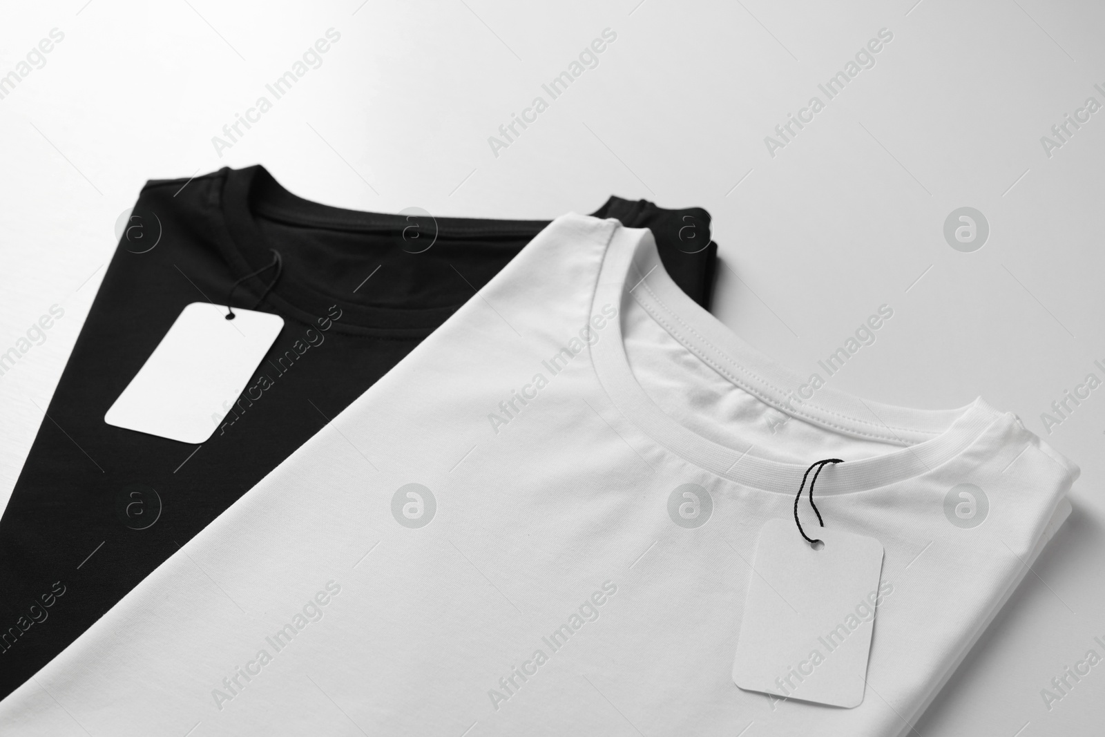 Photo of Different blank t-shirts on white background, closeup. Mockup for design